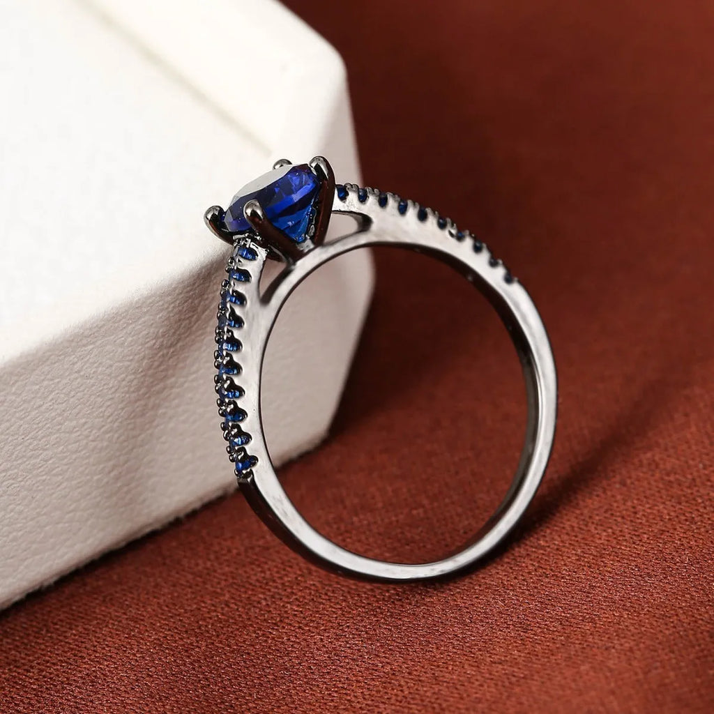 A geometric hexagonal zircon ring in copper, shown in a gold rose red electroplated finish on a size 7 finger.