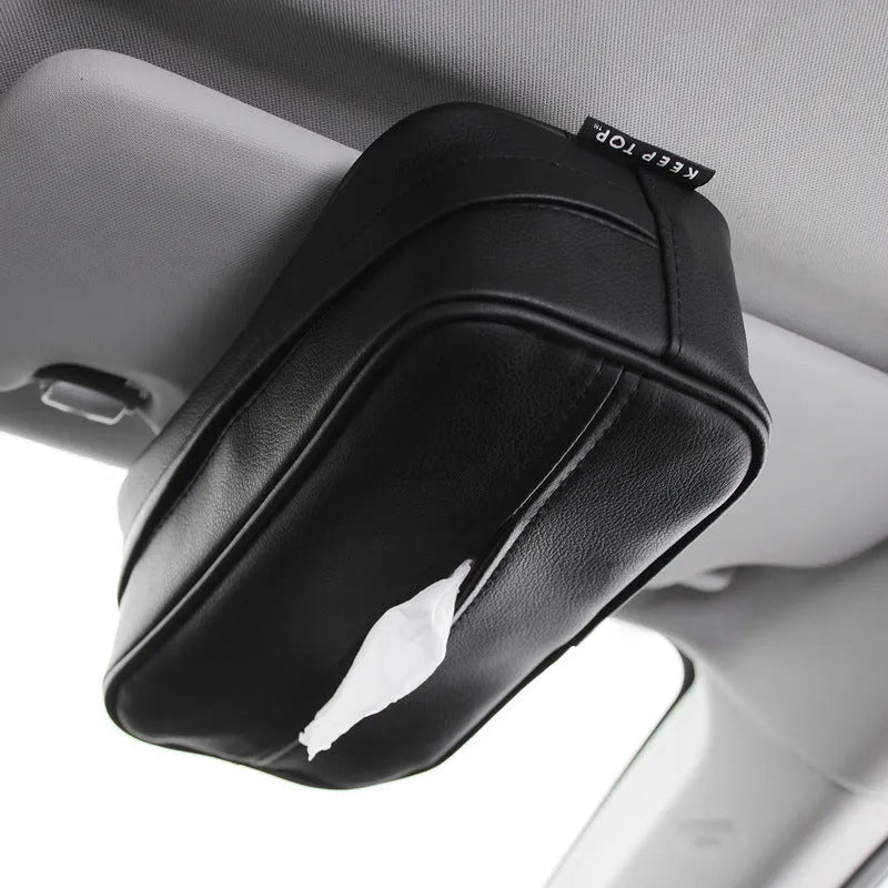 Black leather storage box with removable paper bag inside for car and home organisation.