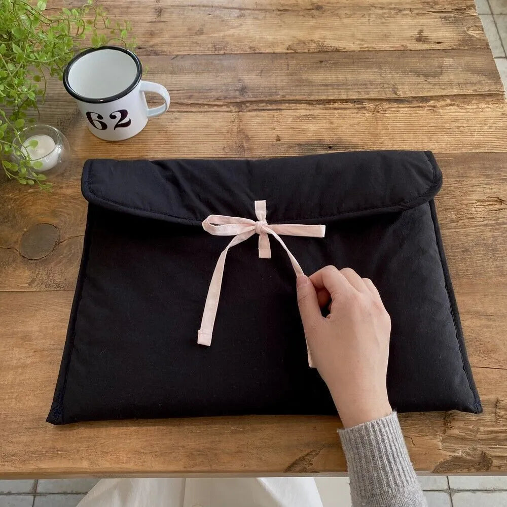 Women's black quilted laptop bag with ballet bow detail and striped pattern showing 11-inch size