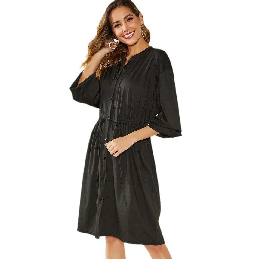 Black or red A-line mid-length dress with elastic waist, long sleeves with elastic cuffs, and a loose cinching belt.