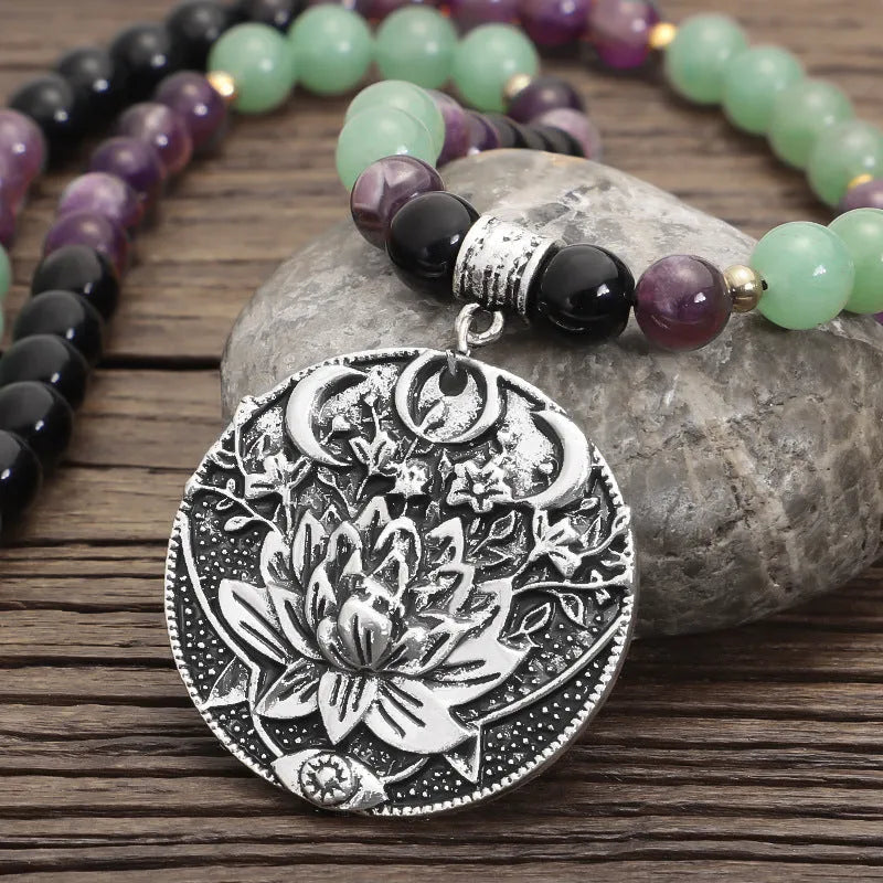 Long yoga necklace with lotus pendant and stone beads alongside matching bracelet
