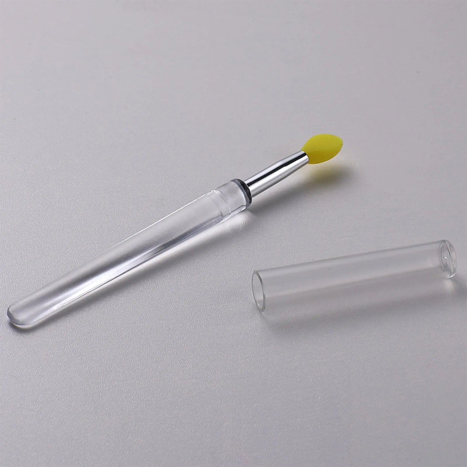 Set of reusable silicone lip brushes with protective caps in eight different colours: blue, pink, purple, red, rose red, skin colour, white, and yellow.