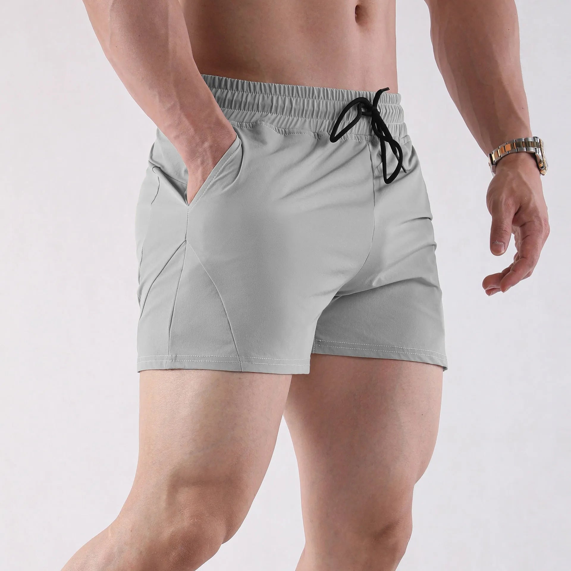 Men's thin grey polyester basketball shorts with an elastic waistband laid flat