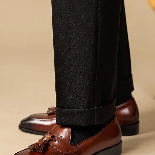 Black leather tassel loafers with polished finish and decorative tassel detail