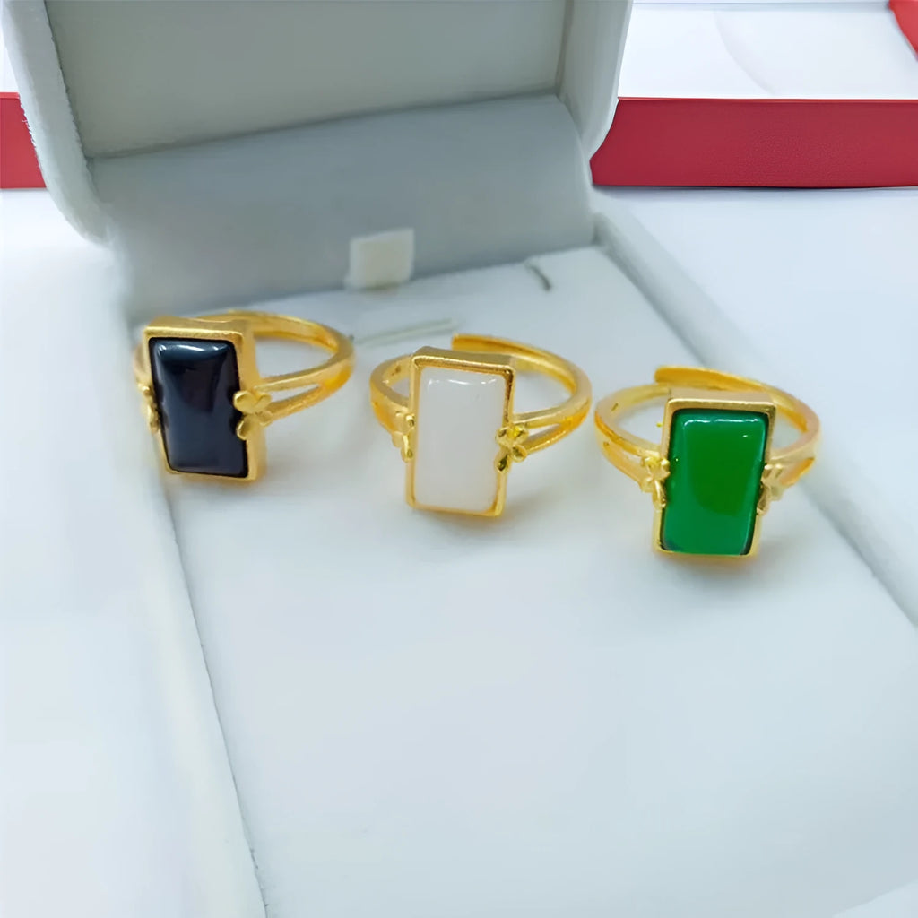 Adjustable brass gold-plated ring with a long black gemstone inlay on a finger.