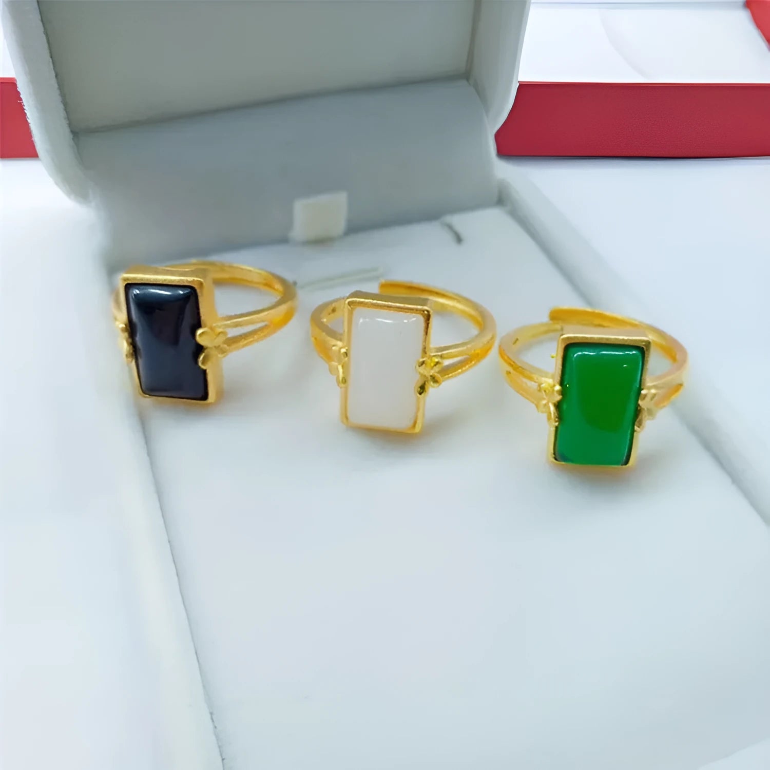 Adjustable brass gold-plated ring with a long black gemstone inlay on a finger.
