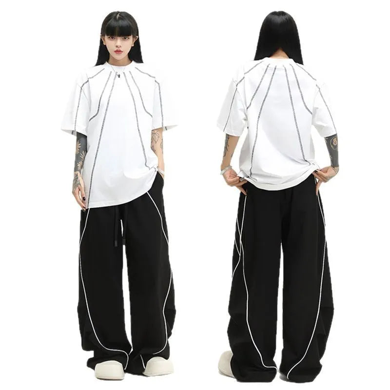 Black and white striped pleated wide-leg hip hop sports pants on a mannequin, showing loose fit and mid waist.