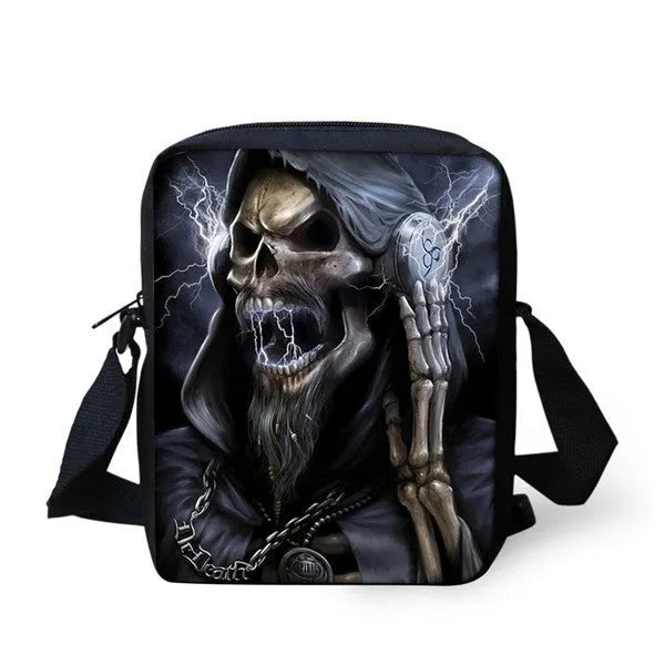 A medium-sized black children's messenger bag with a white skull graphic, showing the double straps and front zipper pocket.