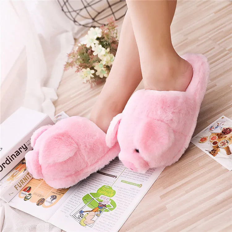 Pink pig-shaped floor slippers with a soft plush fabric exterior.