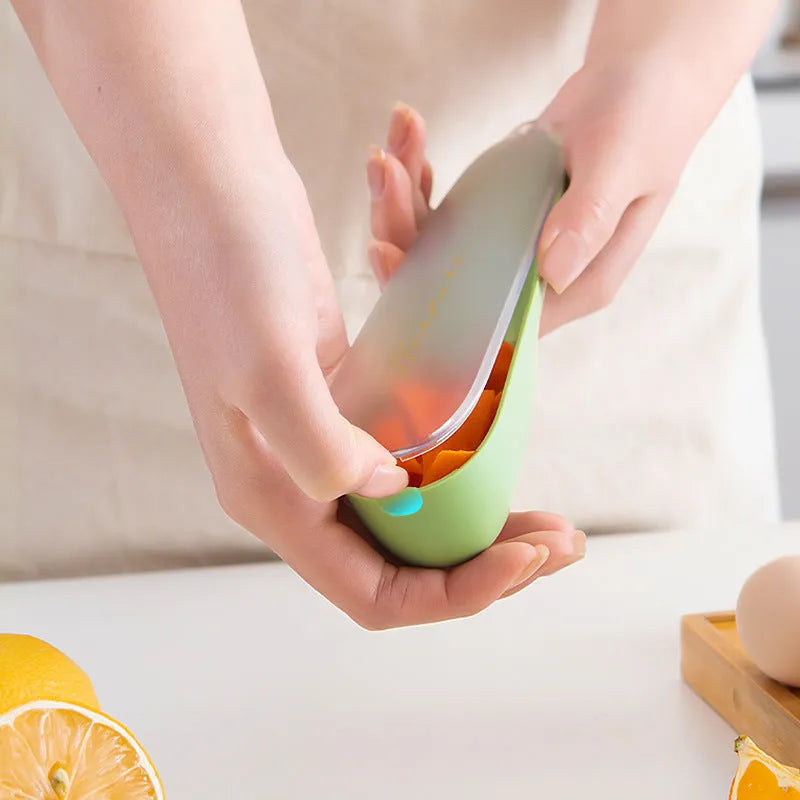 Dark green kitchen peeler with stainless steel blade inside its open storage tube on a counter.