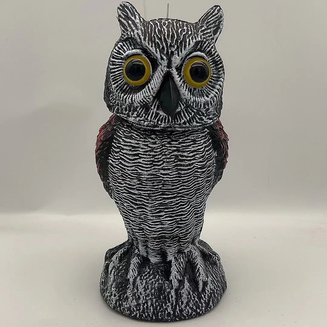 Artificial owl bird deterrent ornament with moving head in outdoor setting