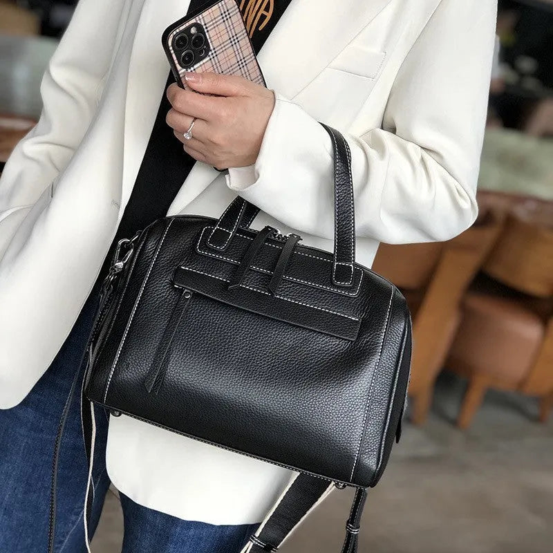 Brown genuine leather messenger bag with a textured lychee pattern, showing front flap and adjustable shoulder strap.