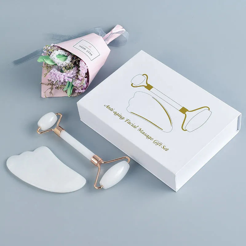 Natural white jade double-headed facial roller and matching scraping board set on a flat surface.