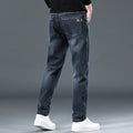 Man wearing blue grey slim straight casual trousers with a loose fit for summer street fashion.