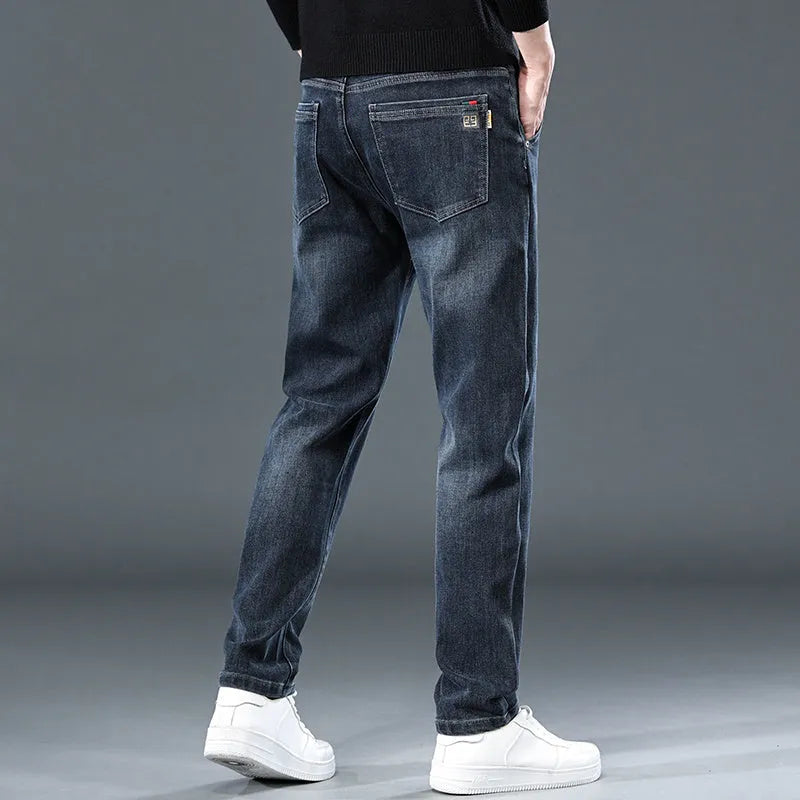 Man wearing blue grey slim straight casual trousers with a loose fit for summer street fashion.