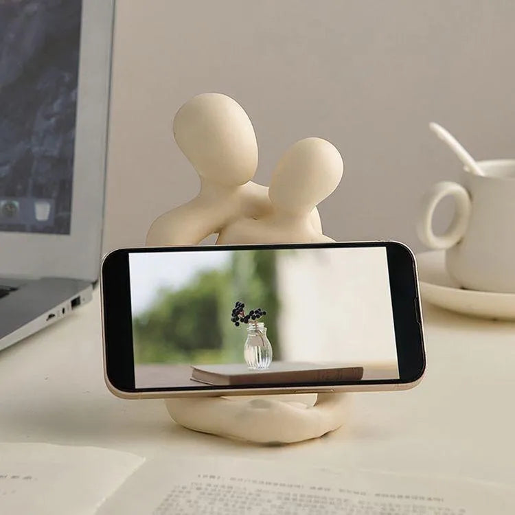Modern couple resin statue in gold finish on a wooden desk.