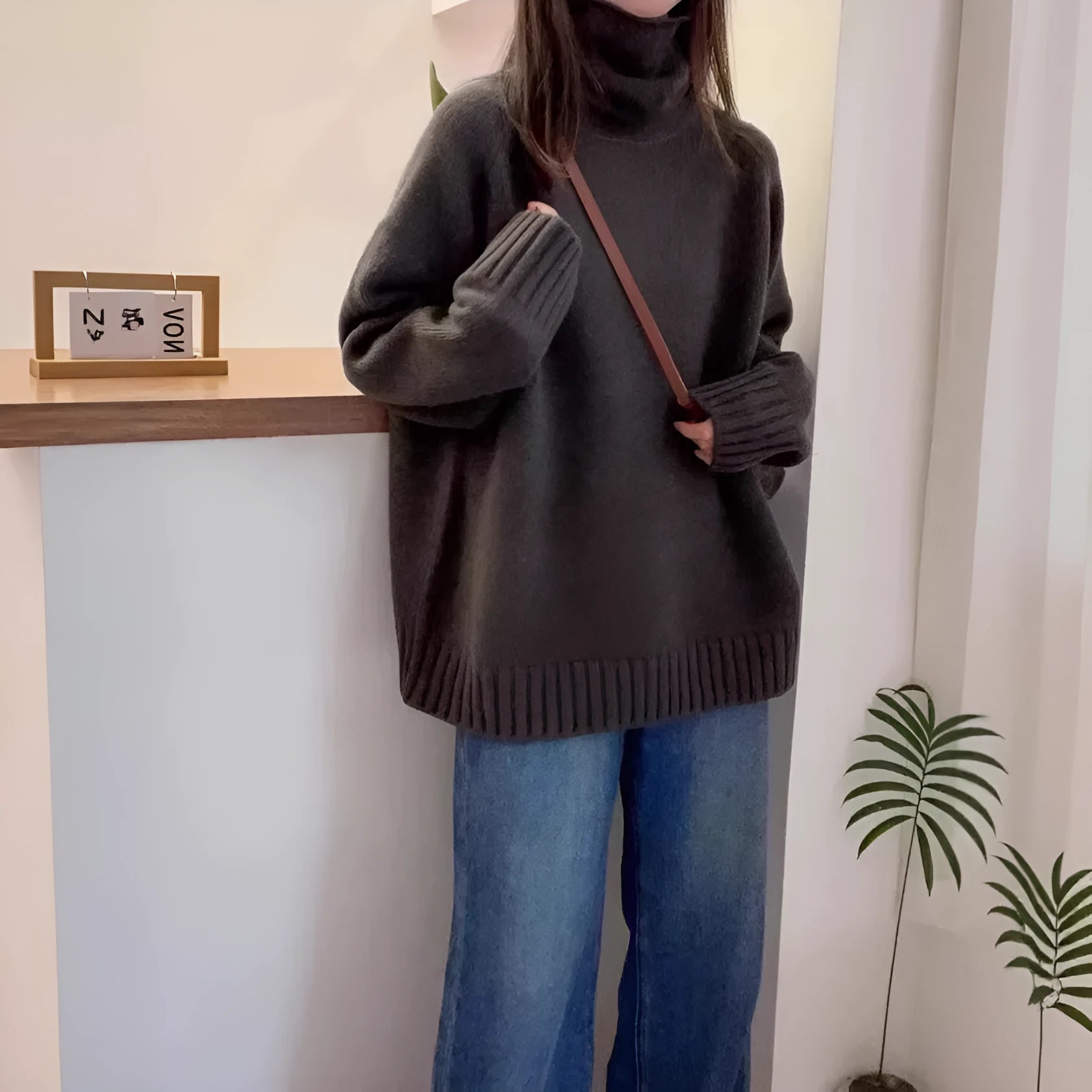 Women's thick turtleneck sweater in solid color with loose casual fit and curled pile collar detail, available in red, camel, gray, and black