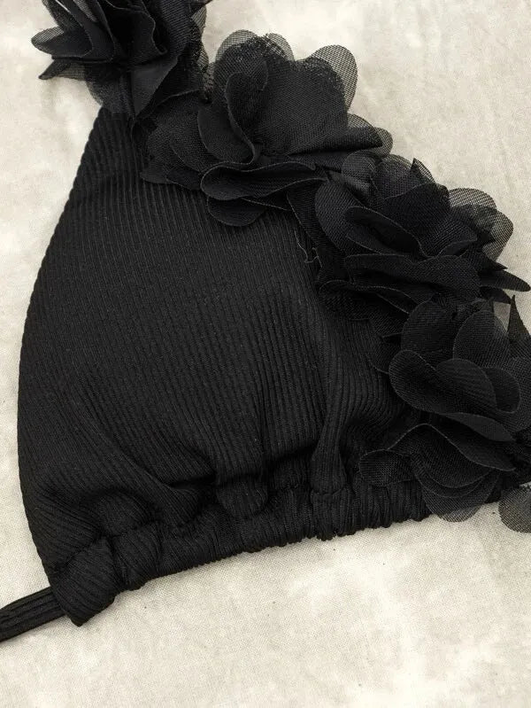 Black gathered style women's bikini top and shorts swimwear set on a mannequin
