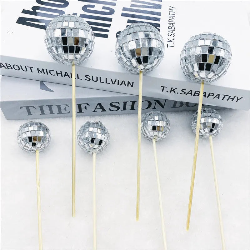 Glass mirror disco ball cake topper on a wooden stick for birthday party cupcakes.