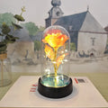 Small decorative night lamp with a glass cover and plastic flowers on a black base.