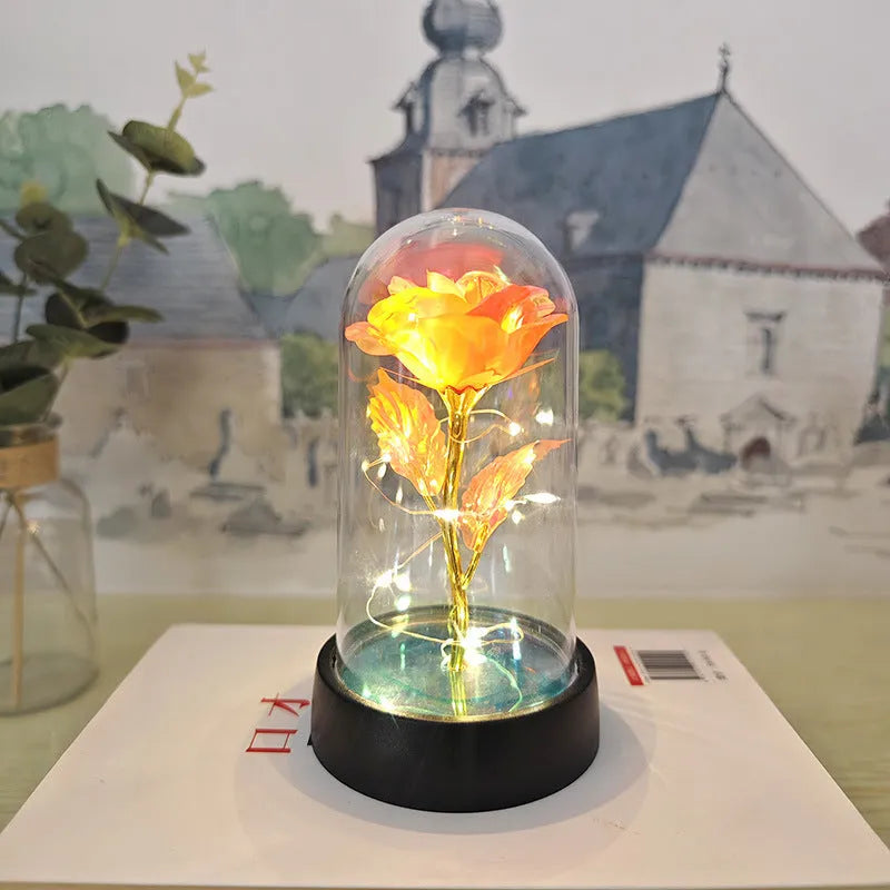 Small decorative night lamp with a glass cover and plastic flowers on a black base.