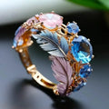 Gold coloured brass ring with an embossed geometric feather design and small zircon inlays.
