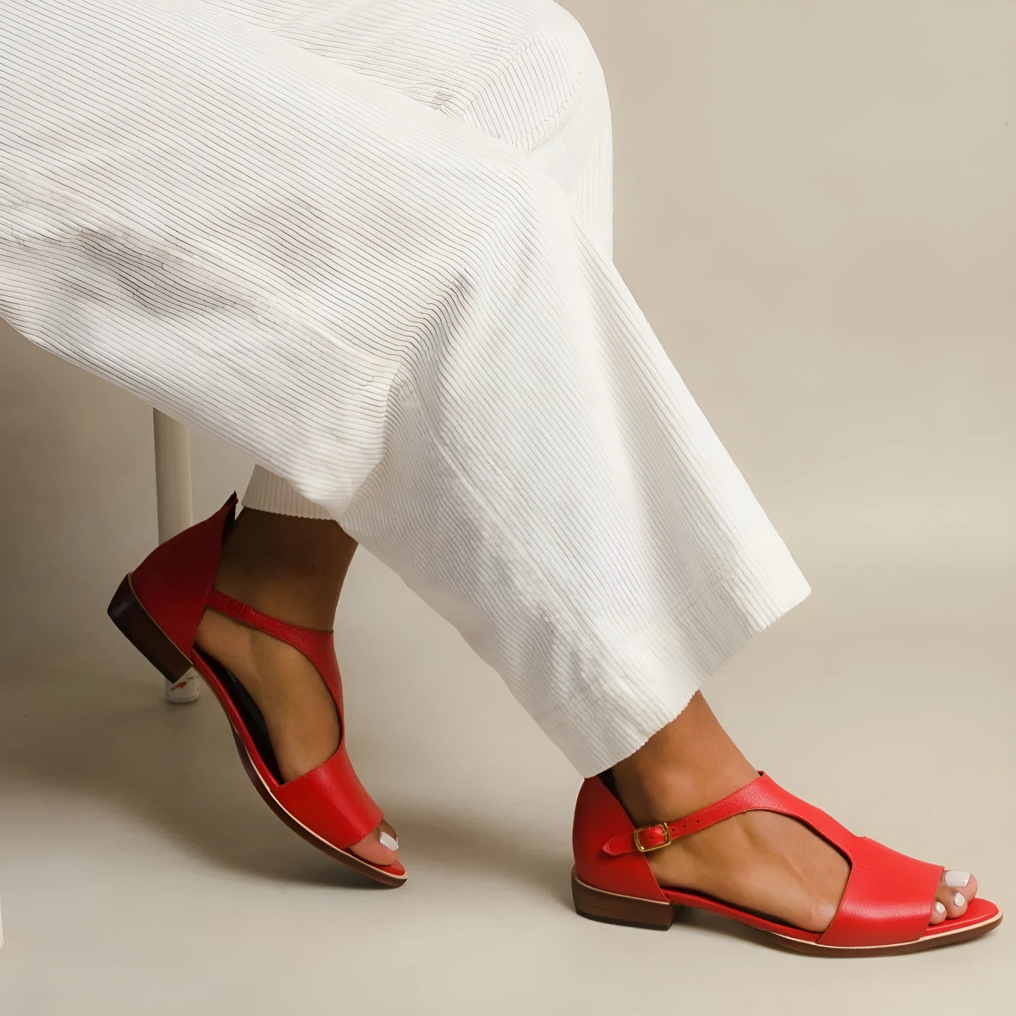 Red women's casual sandals with a square buckle and herringbone toe design, shown on a white background.