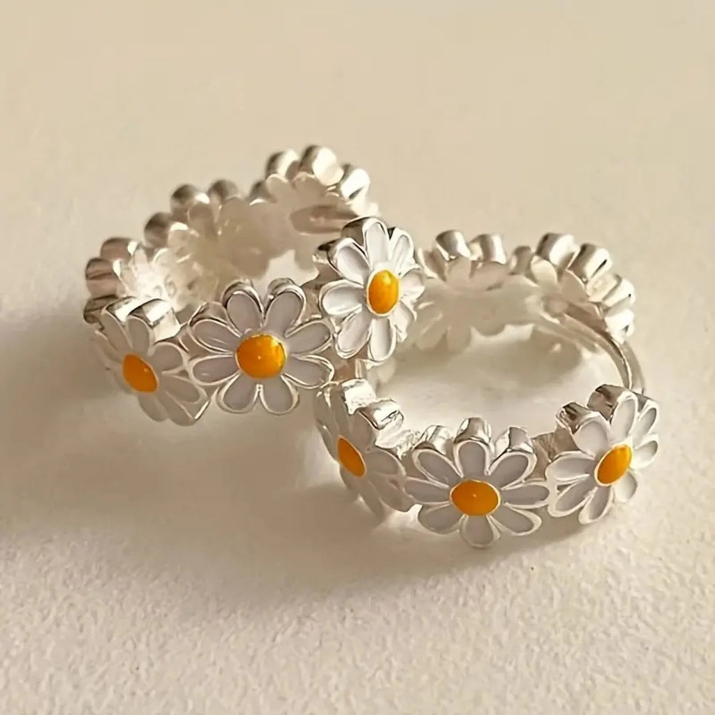 Pair of white daisy flower-shaped ring earrings with a gem inlay detail.