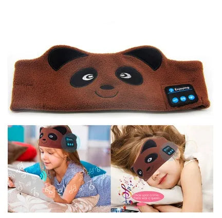Black Bluetooth sleep eye mask with small integrated wireless earphones, shown in a relaxed position on a pillow.