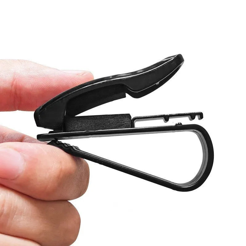 Black plastic car sun visor clip organiser for glasses and cards on a car interior.