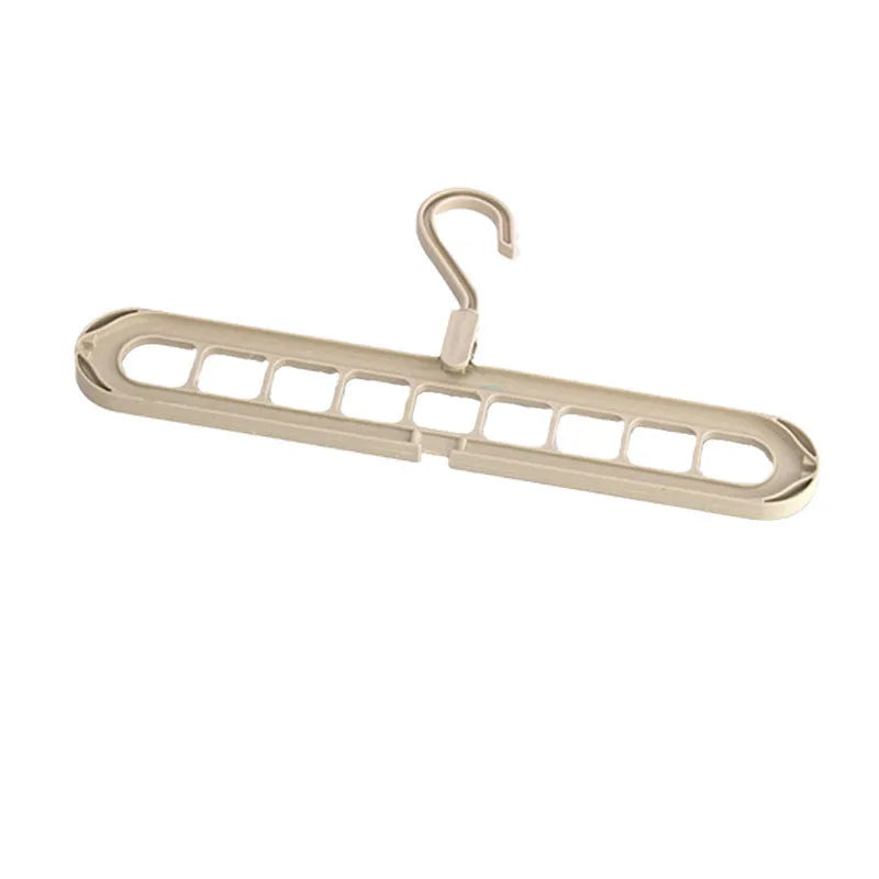 Green plastic nine-hole folding trouser hanger showing multiple trousers hung