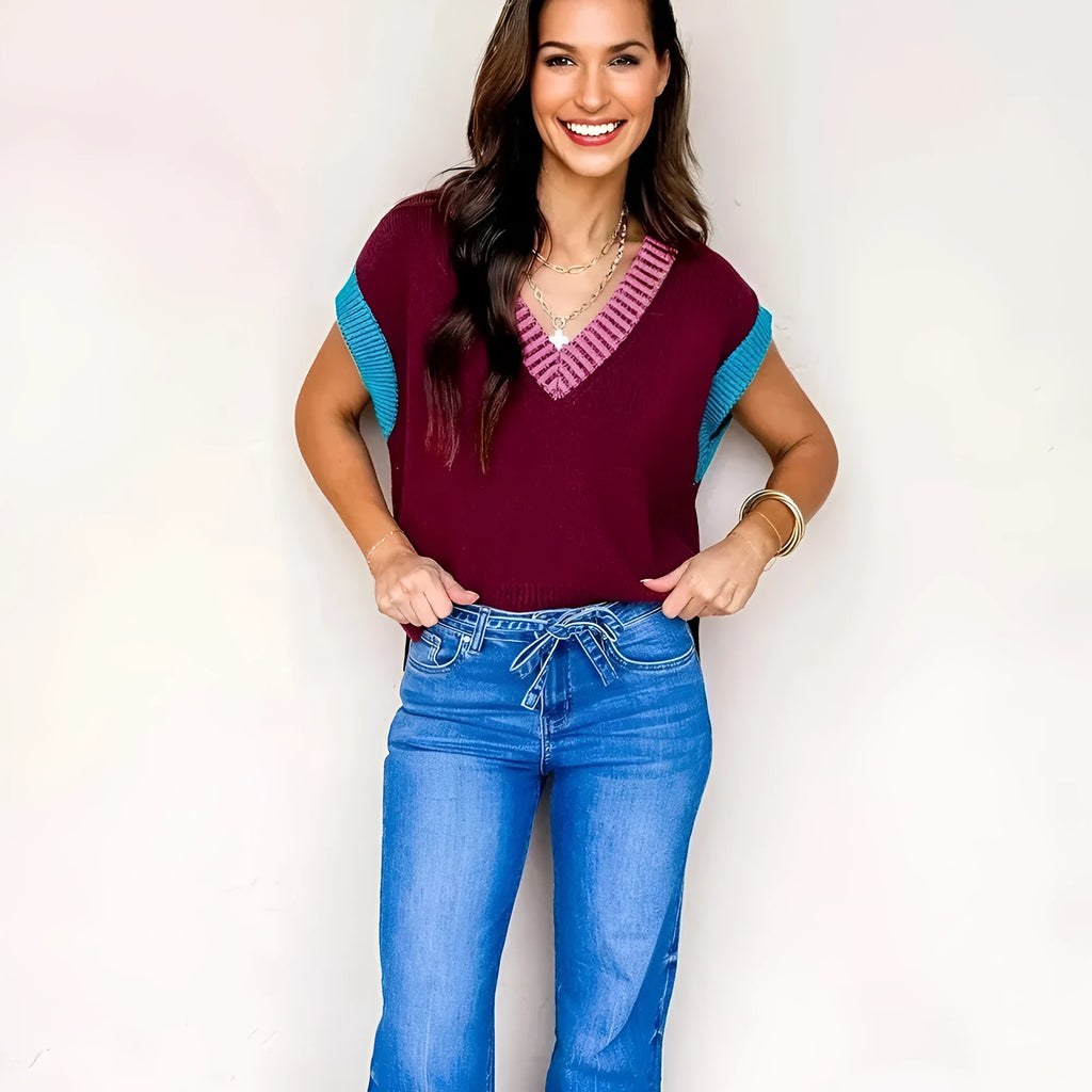 Burgundy loose V-neck sweater with contrast trim and short cuffed sleeves laid flat.