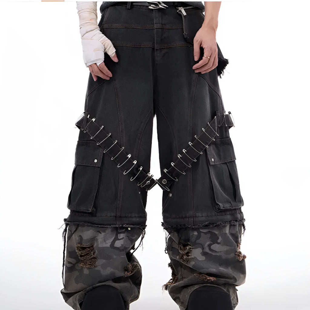 Grey men's jeans with camouflage pattern splicing and silver pin and black ribbon detailing on the legs.