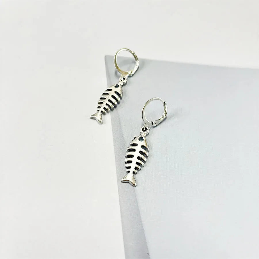 Silver-colour fishbone pendant necklace with O-chain and matching earrings on grey background