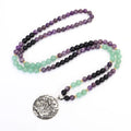 Long yoga necklace with lotus pendant and stone beads alongside matching bracelet
