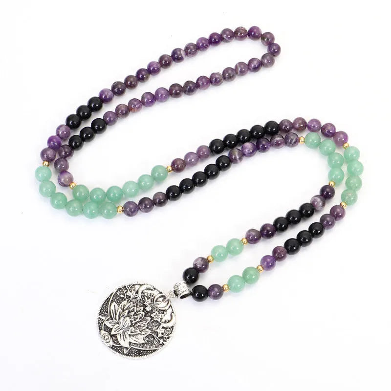 Long yoga necklace with lotus pendant and stone beads alongside matching bracelet