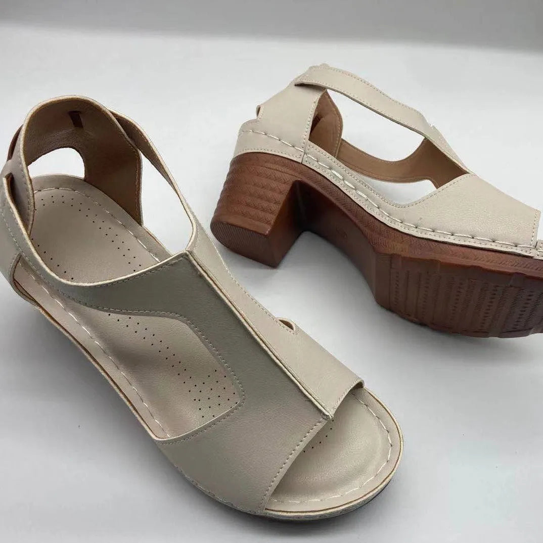 Women's beige peep toe wedge sandals with an adjustable ankle buckle strap on a foot.