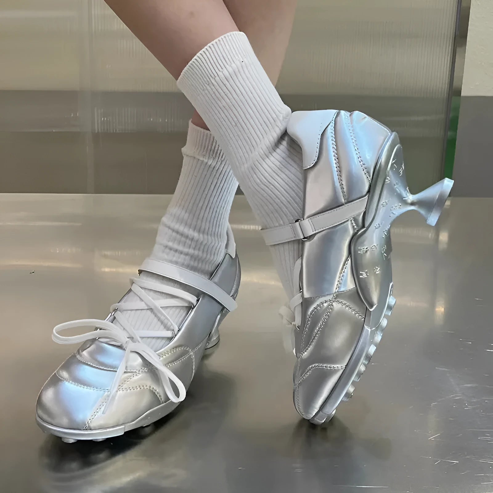 Women's silver lace-up sports shoes with a bow detail and a mid-height heel on a white background.