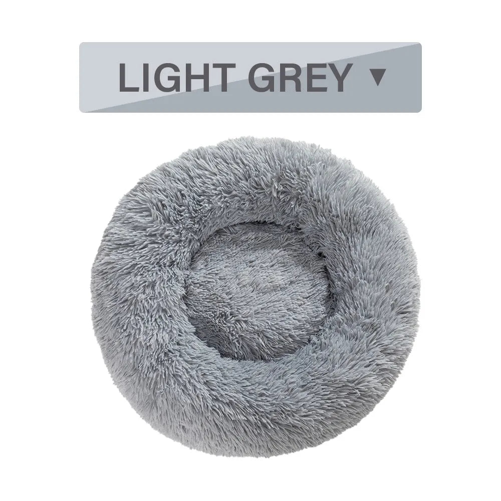 Fluffy grey donut dog bed with raised rim, shown with a small dog sleeping inside.