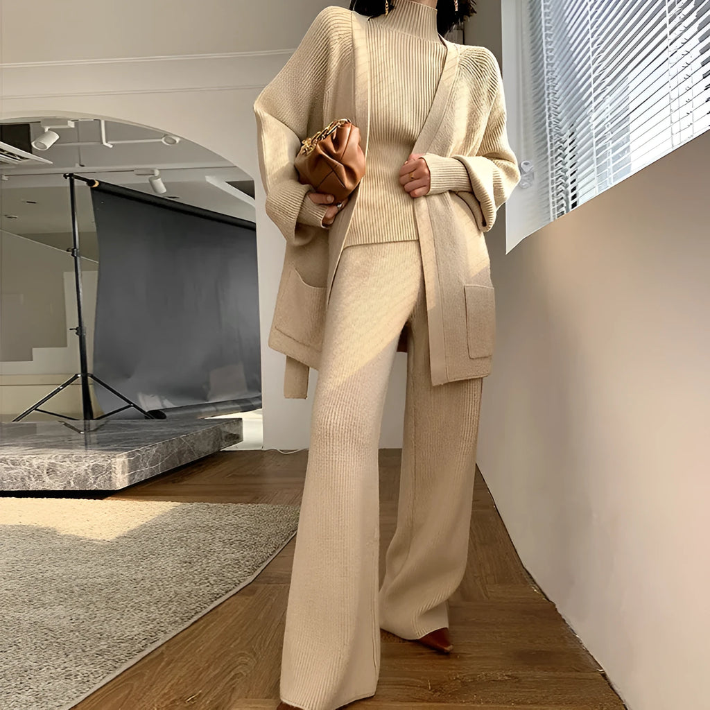 Women's apricot knitted three-piece set showing top, cardigan, and wide-leg trousers with leather stitching detail.