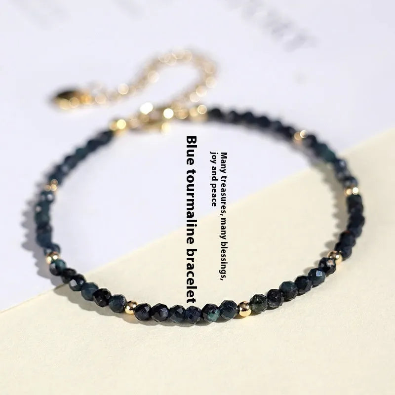 Blue tourmaline bracelet with 3mm cut beads and spacer design on white background