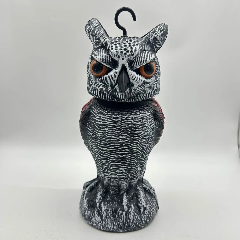 Artificial owl bird deterrent ornament with moving head in outdoor setting