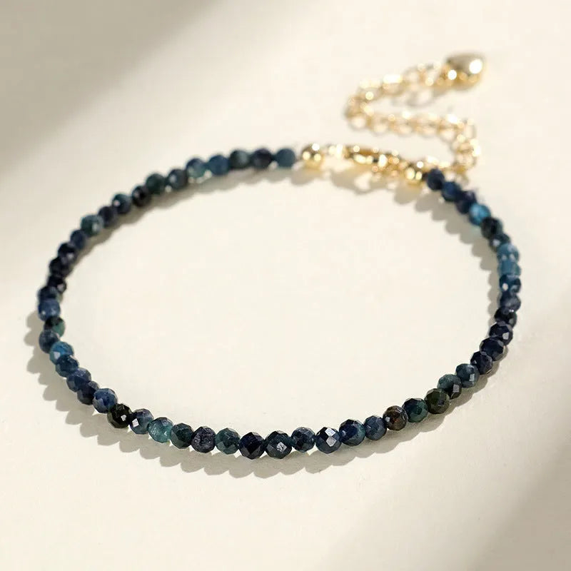 Blue tourmaline bracelet with 3mm cut beads and spacer design on white background