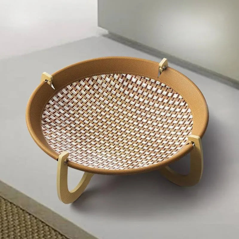 Natural brown woven rattan pet hammock with raised sides on a wooden floor.