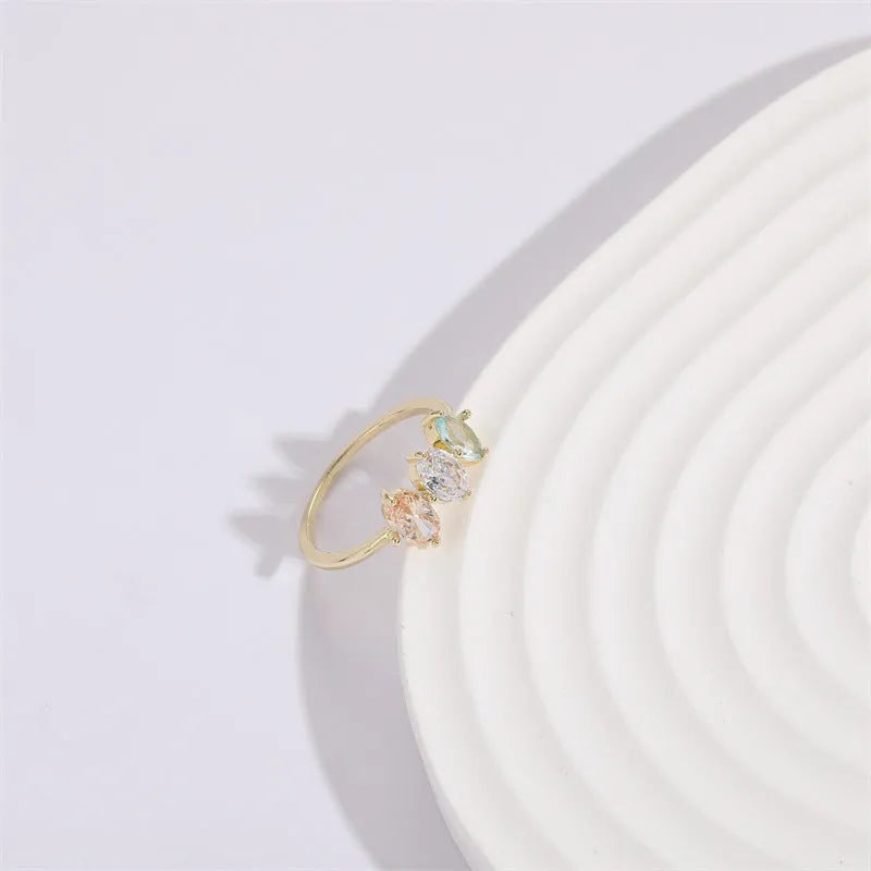 Geometric triangle ring with tricolour zircon birthstone in gold electroplated finish.