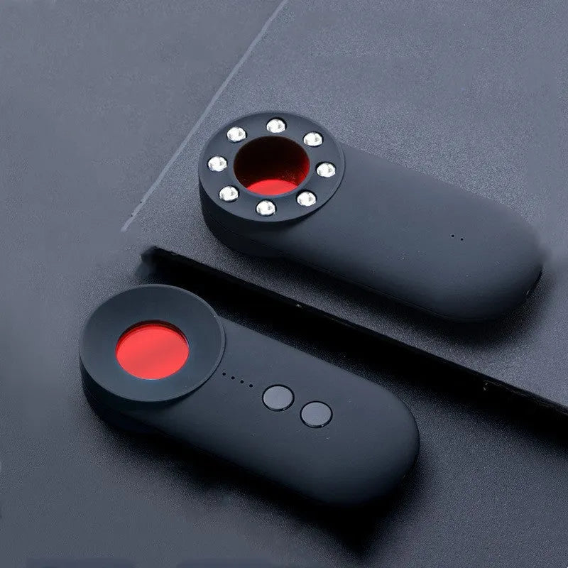 Black portable GPS and WiFi signal detector with laser scanner for hidden cameras on a table.
