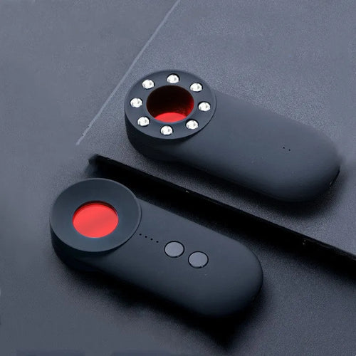 Black portable GPS and WiFi signal detector with laser scanner for hidden cameras on a table.