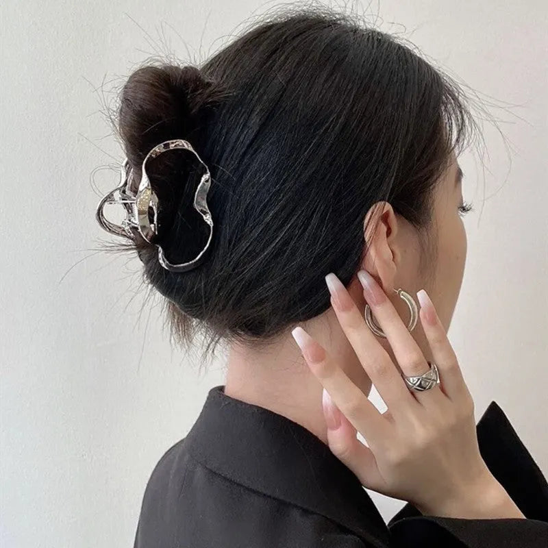 Silver metal hair claw barrettes collection showing multiple designs including wave, rose, and bow shapes