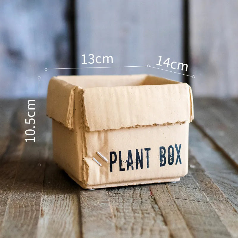 Cement flower pot with brown paper box texture and drainage holes, shown in a neutral home setting.