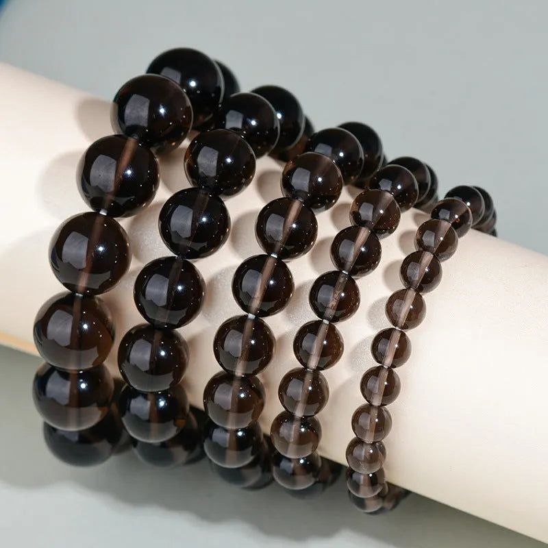 Hand-woven obsidian bracelet with round crystal beads in natural black stone